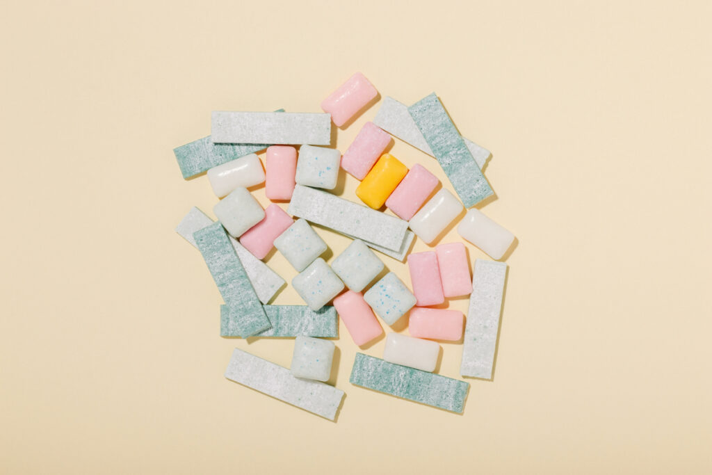 Различные виды жвачки на желтом фоне