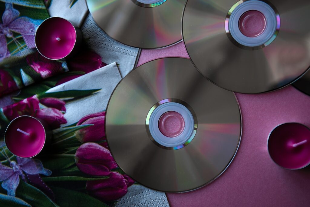 компакт диски на розовом фоне