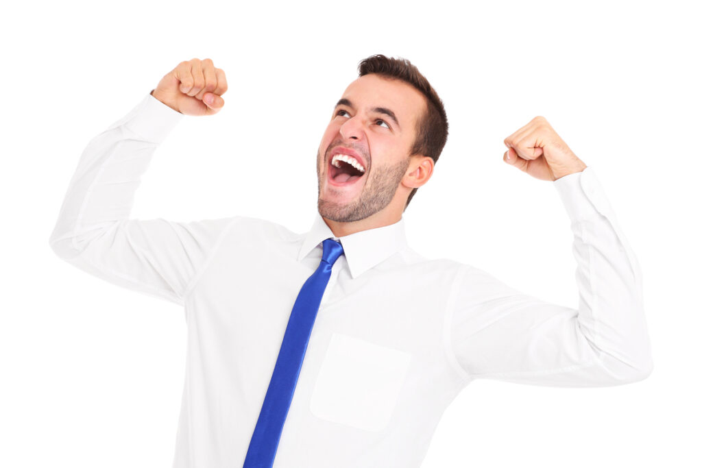 Молодой бизнесмен в костюме радуется
