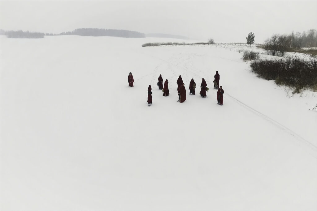 Тибетские монахи в снежной местности
