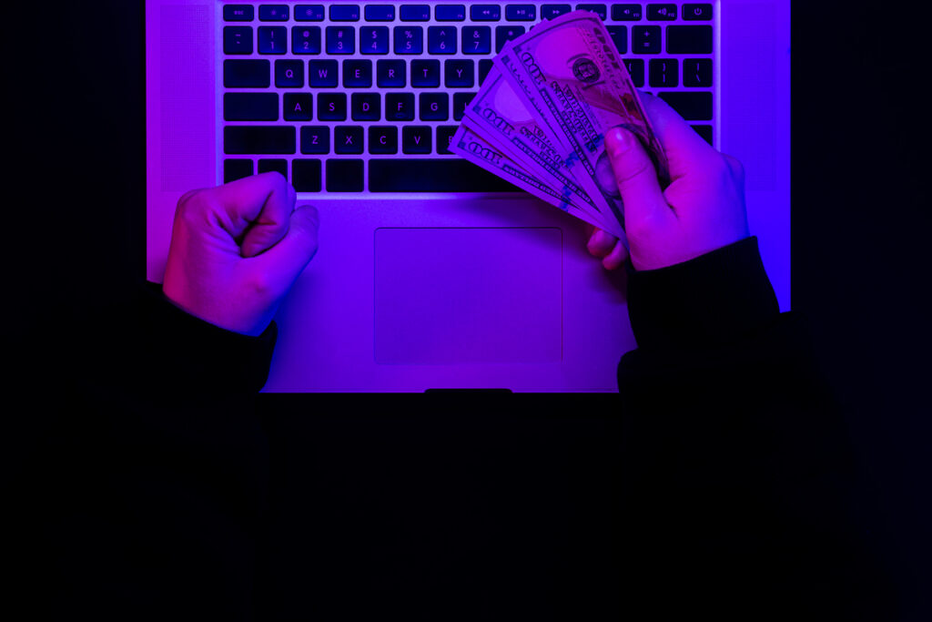 деньги в мужских руках на фоне клавиатуры