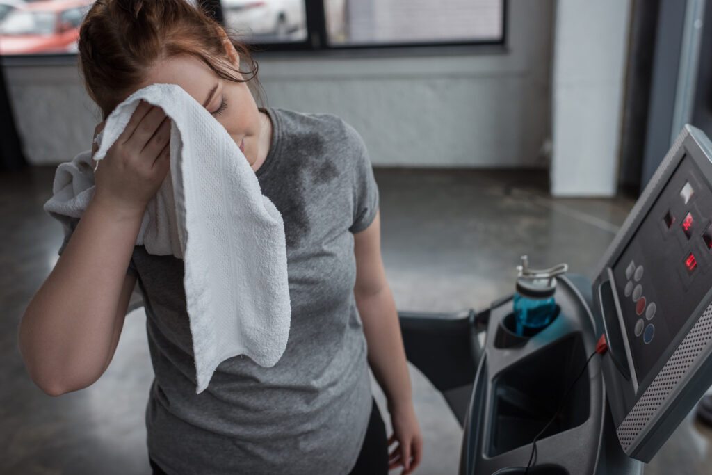 Девушка вытирает лицо во время бега