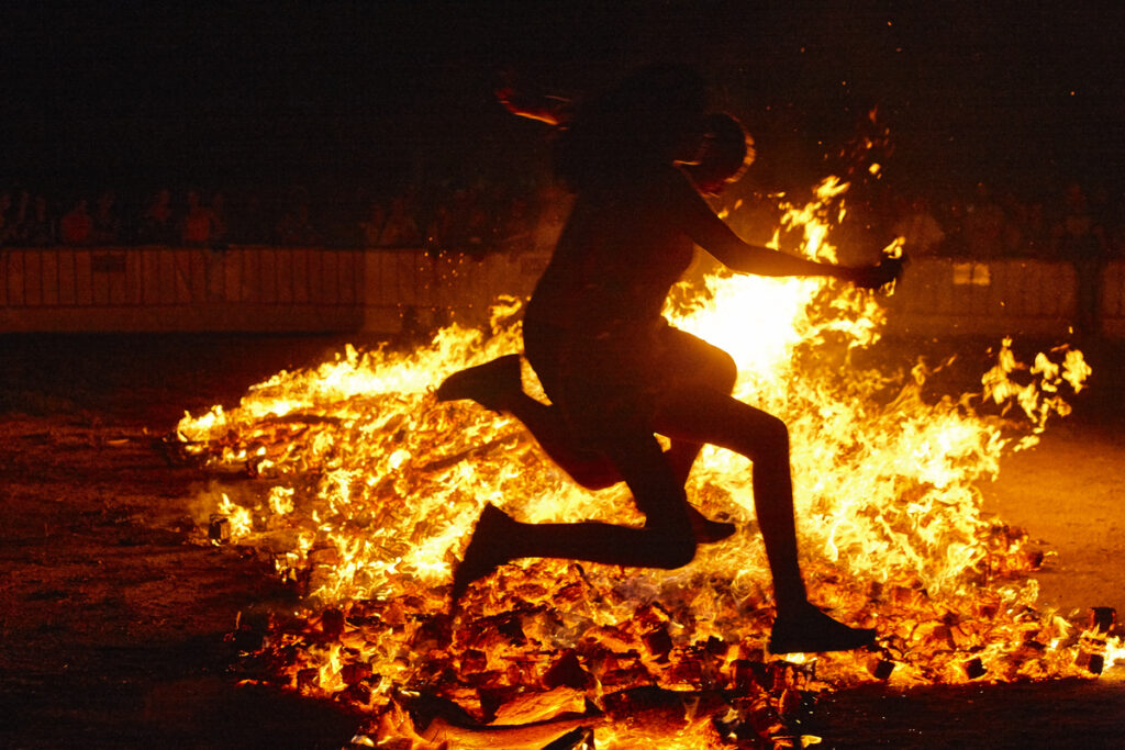 Человек прыгает через огонь