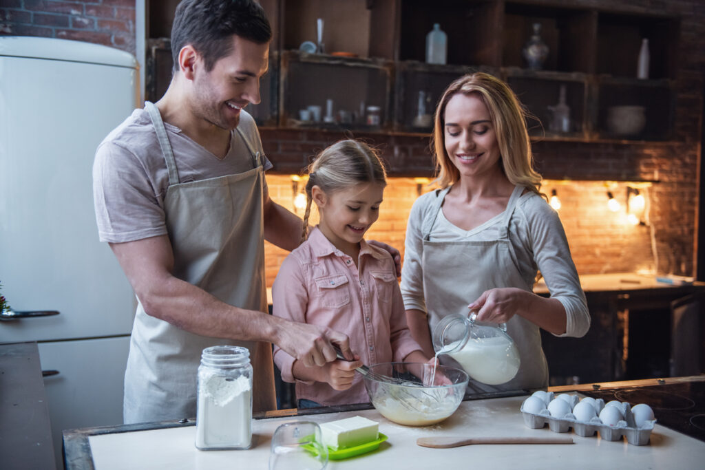 Семья готовит блины на кухне