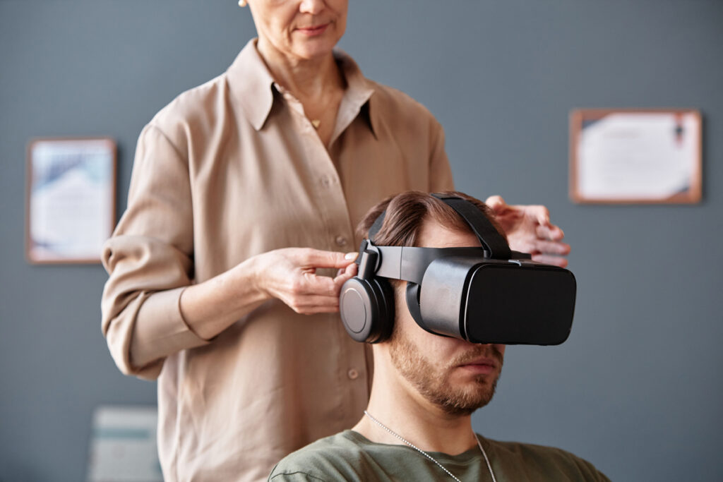 Женщина помогает мужчине с VR-гарнитурой