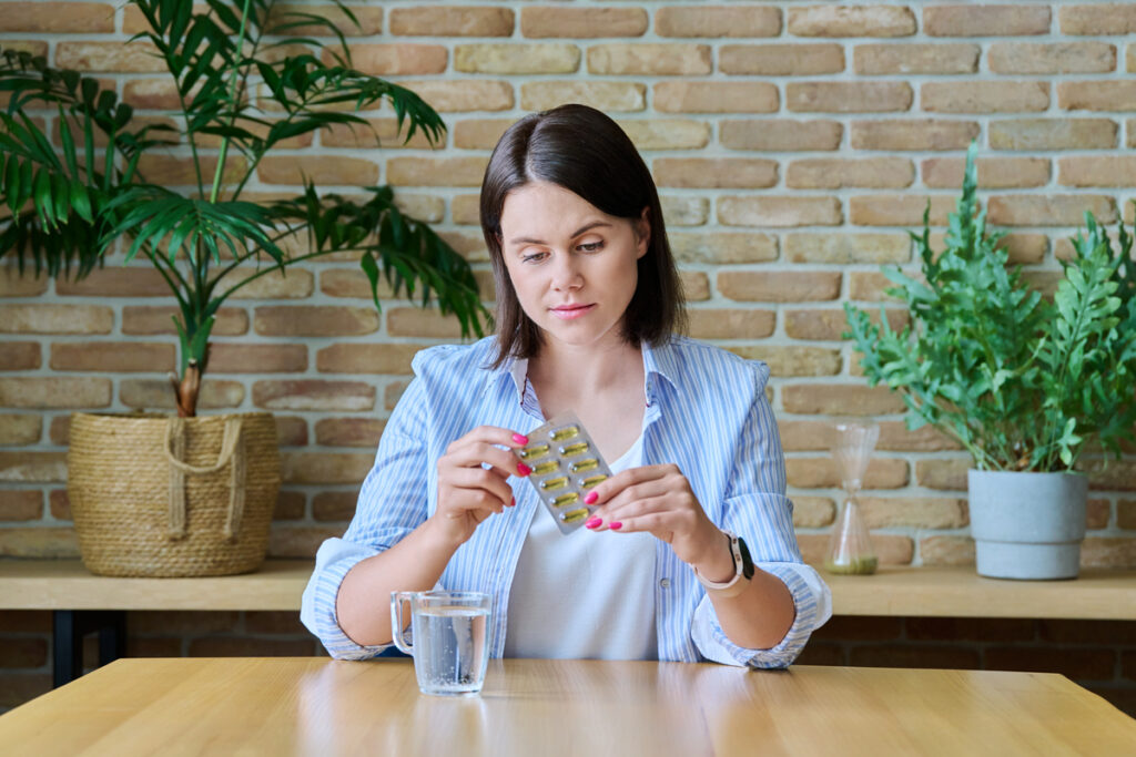 Женщина с лекарствами и стаканом воды