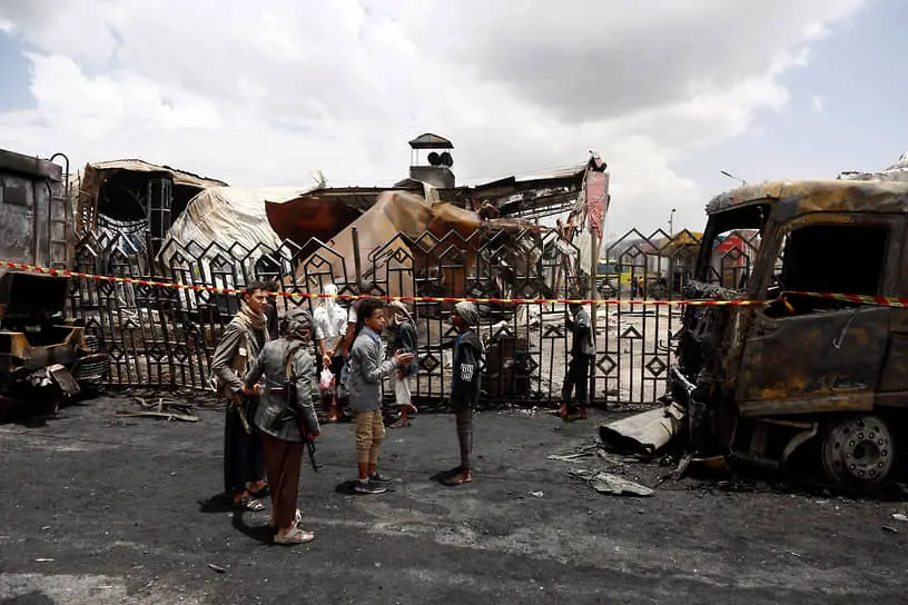 Жители Саны на сгоревшей заправке в результате израильского удара, 25 августа