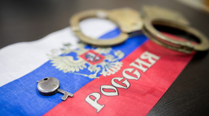 Russia flag and police handcuffs The concept of observance of the law in the country and protection from crime