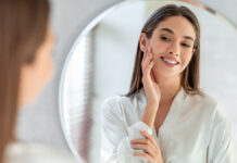 Self-careConceptPortraitOfAttractiveYoungFemaleLookingAtMirror