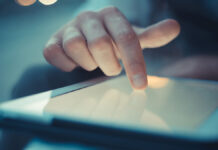 Рынок планшетов в России достиг исторического максимума CloseUpHandManUsingTabletAtTheBarWith