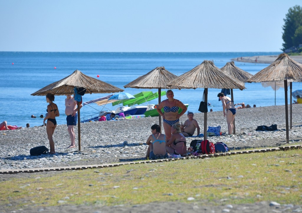 Отдыхающие на пляже Пицунды в Абхазии