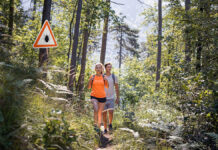 Как сохранить здоровье в сезон активности клещей ManAndWomanHikingInInfectedTicksForestWithWarning