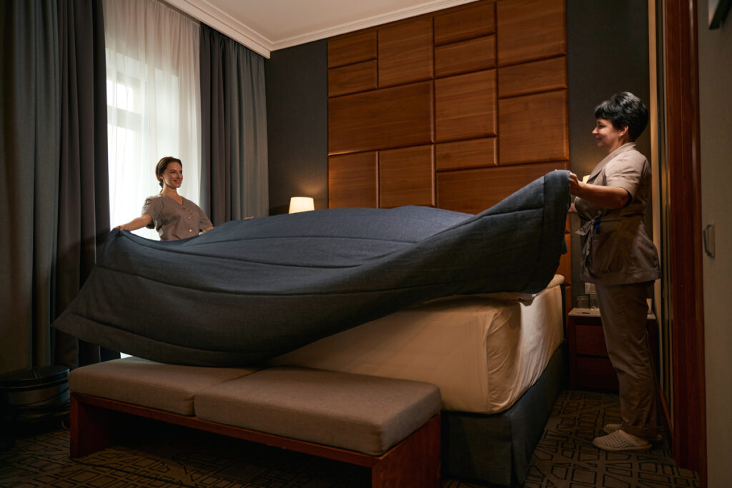 женщины заправляют кровать