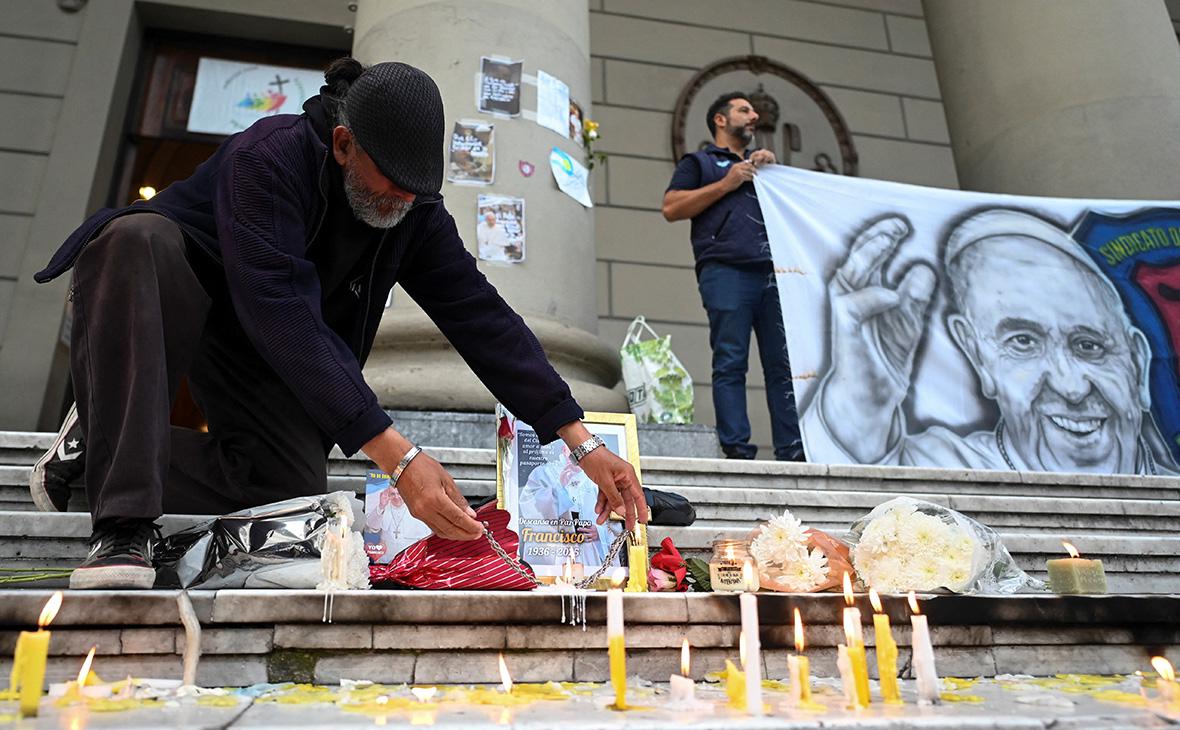 Стихийный мемориал у кафедрального собора Буэнос-Айреса после смерти папы римского Франциска, Аргентина, 21 апреля 2025 года (Martin Cossarini / Reuters)