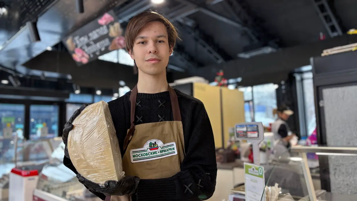 Продавец Марк Осин показывает один из крафтовых сортов сыра