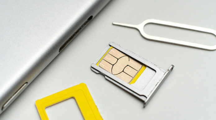 the process of changing the sim card in smartphone flat lay on color surface macro view