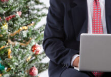Работа в праздники: духовный взгляд на современные реалии businessman with computer by christmas tree
