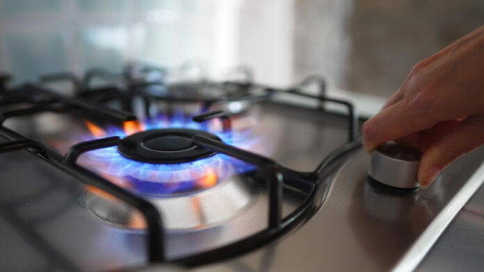 WomanTurningOnTheGasBurnerOnTheStove