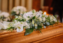 ACoffinDecoratedWithManyFlowersAndCandlesInA