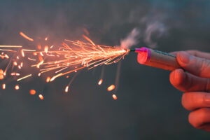 Young,Man,Lighting,Up,Firecracker,In,His,Hand,Outdoors,In