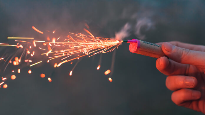 Young,Man,Lighting,Up,Firecracker,In,His,Hand,Outdoors,In