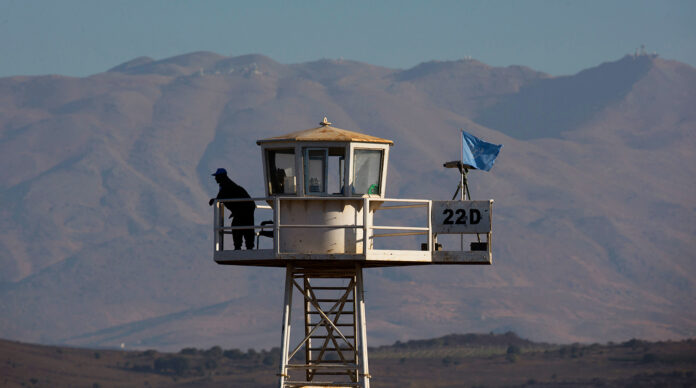 United Nations peacekeeping soldier stands on an observation tower near the Quneitra border crossing, in the Israeli-occupied Golan Heights