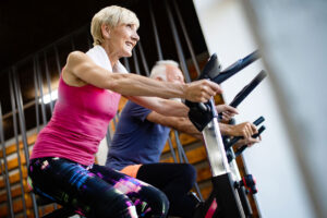 Happy senior people doing indoor biking in a fitness club
