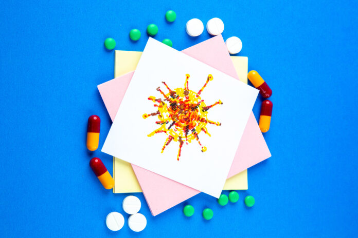 top view paper stickers with different pills on blue background pandemic hospital lab vaccine school covid- color drug рисунок вируса, обложенный таблетками
