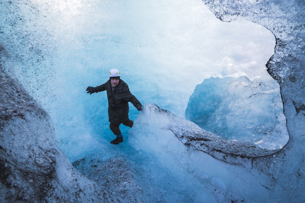 Турист исследует ледяную пещеру