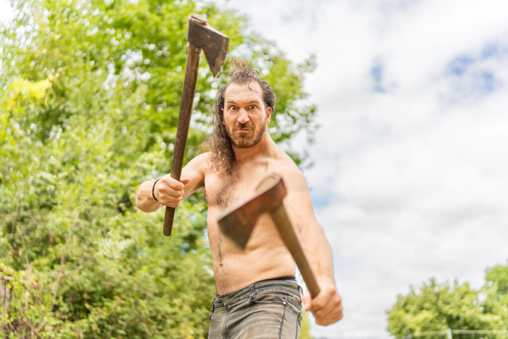 Дикий человек с обнаженным туловищем и двумя топорами