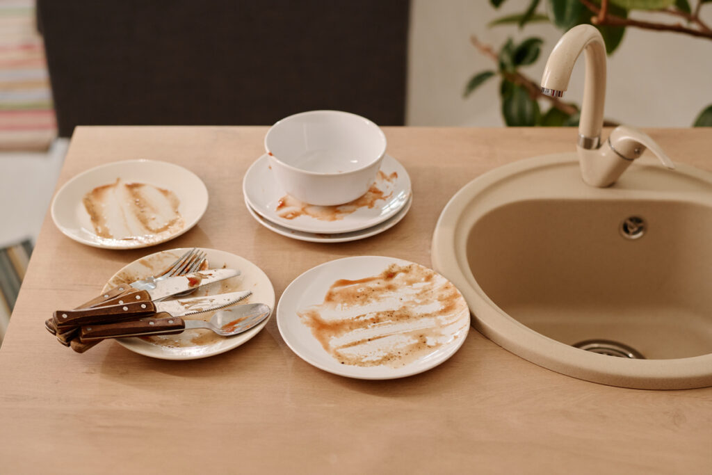 Грязная посуда на кухонном столе у раковины