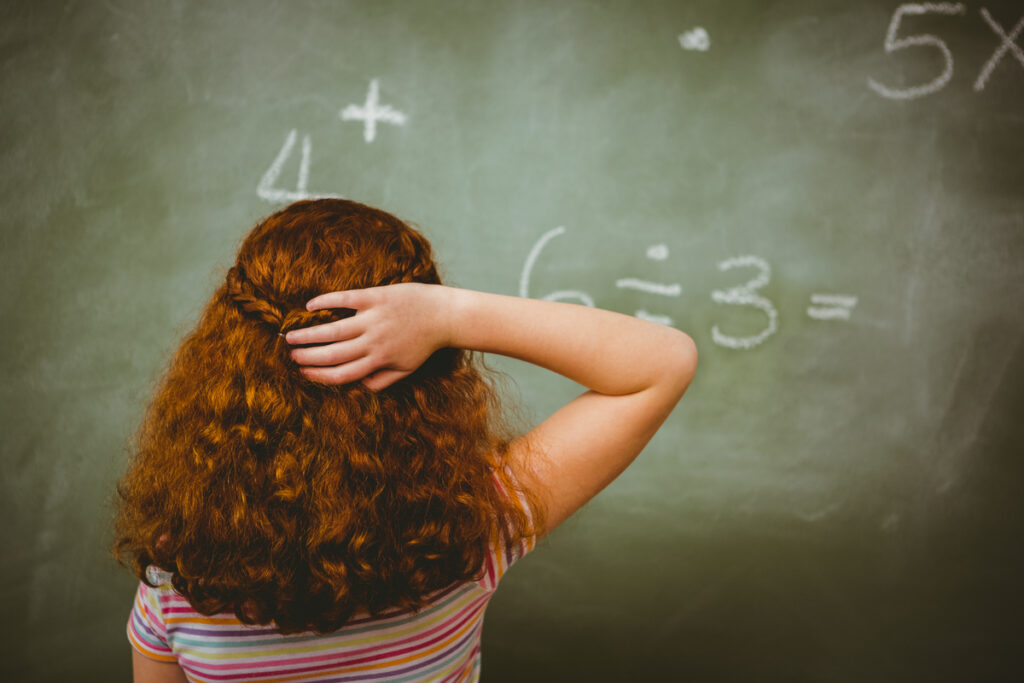 Маленькая девочка, смотрящая на доску в классе