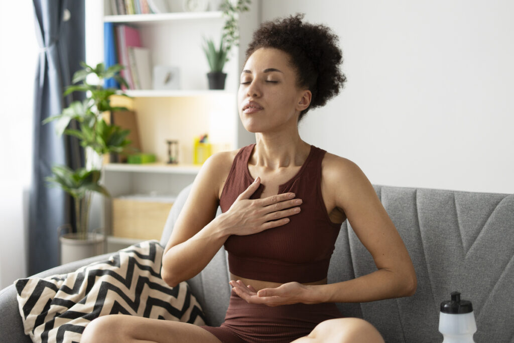 Молодая женщина выполняет упражнения для глубокого дыхания