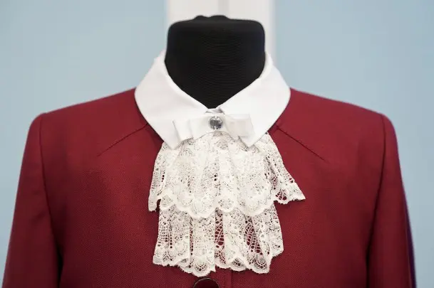 Девочки могут носить форму темно-красного цвета, которая состоит из юбки, пиджака и белой рубашки с ажурным воротничком