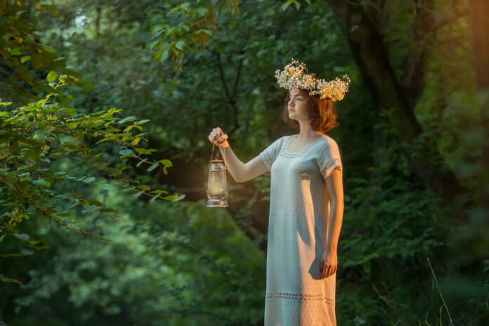 girl is standing in the forest an old kerosene lamp in her hand Девушка в лесу со старой керосиновой лампой