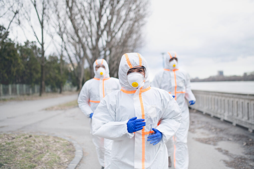 Люди в защитных костюмах и респираторах