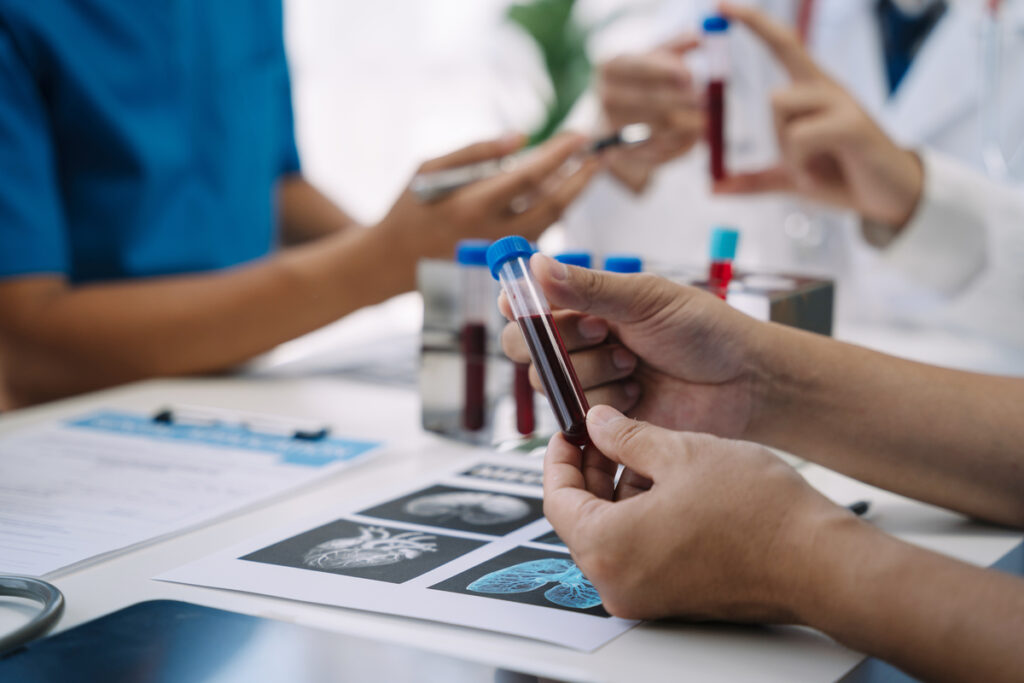 Медицинский работник держит в руках колбу с кровью