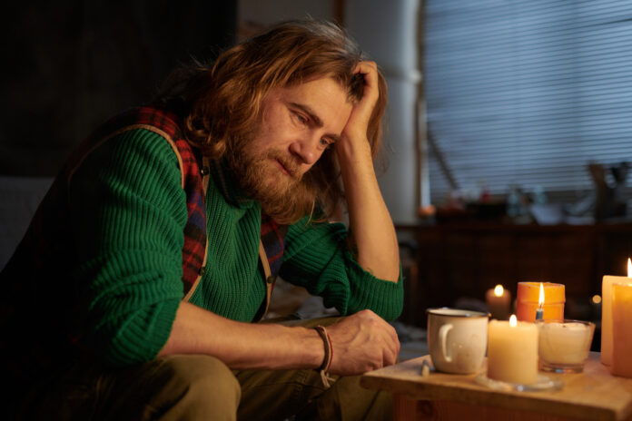 Man Sitting Alone Reflecting by Candlelit Table Мужчина, сидящий в одиночестве