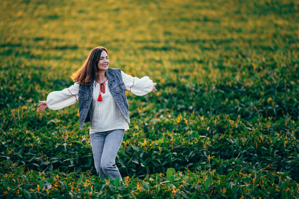 Женщина с распростертыми объятиями танцует