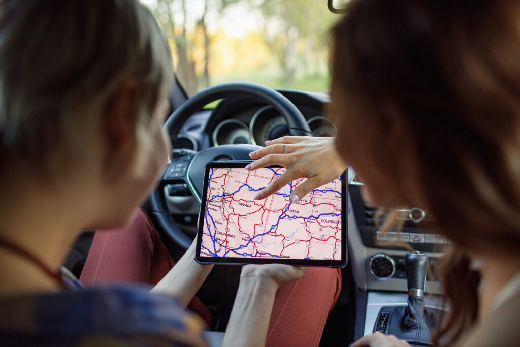 Женщины пользуются GPS-навигатором в автомобиле