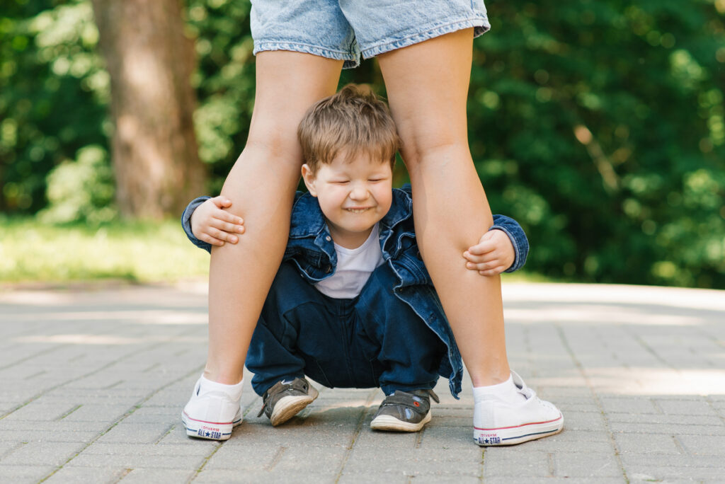 ребенок спрятался за ноги мамы
