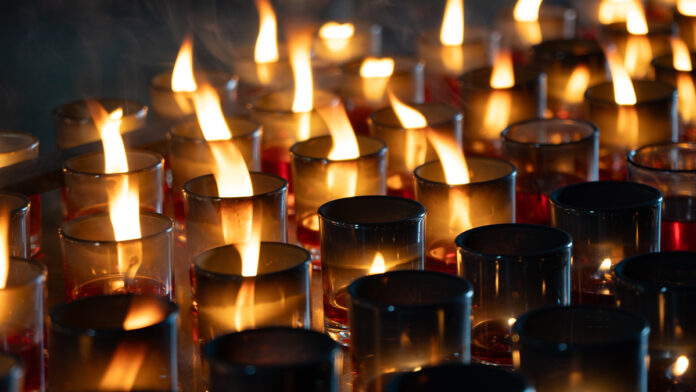 DetailOfManyRedVotiveCandlesLightInsideChineseTemple