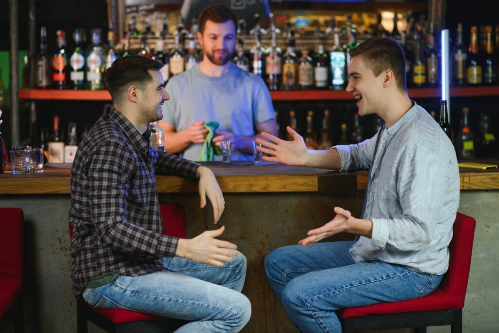 молодые люди разговаривают в пабе
