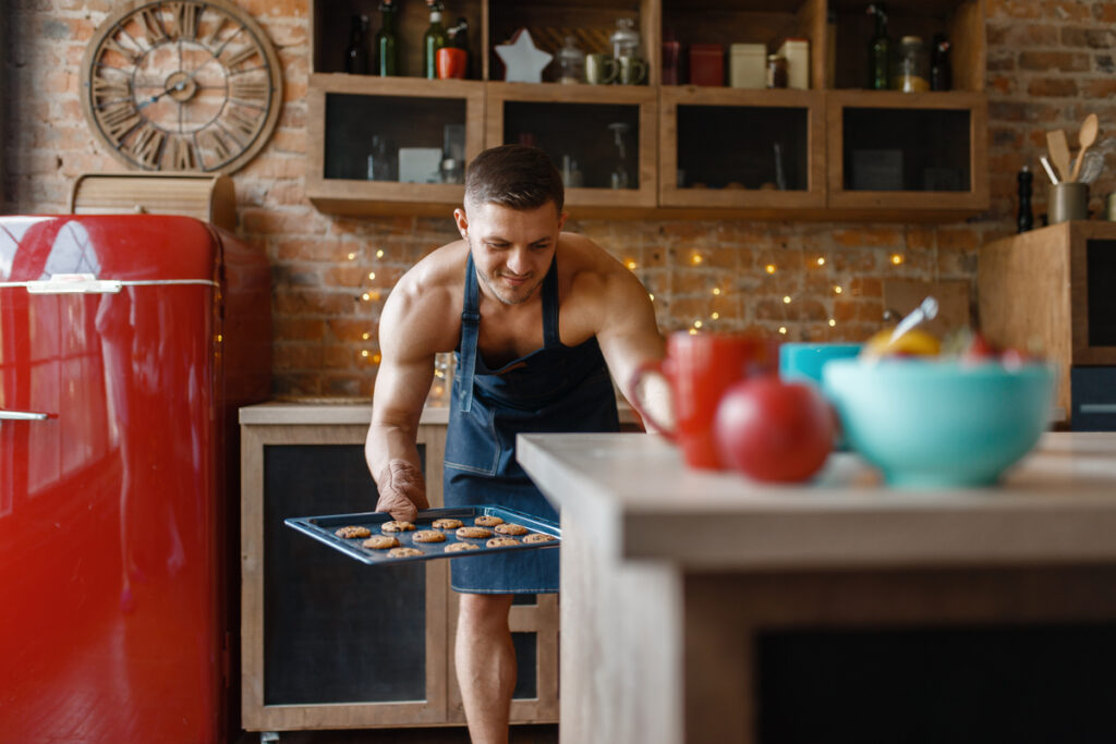 мужчина в фартуке готовит выпечку на кухне