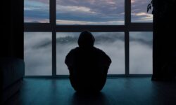 одинокий человек сзади сидит у окна