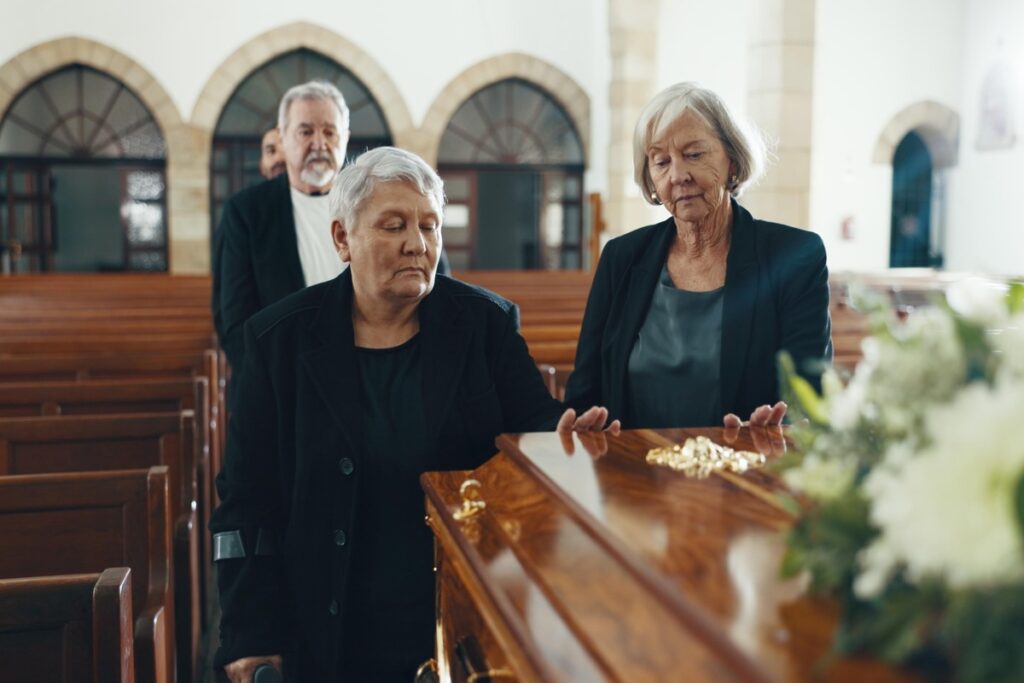 Пожилые женщины, гроб и похороны в церкви
