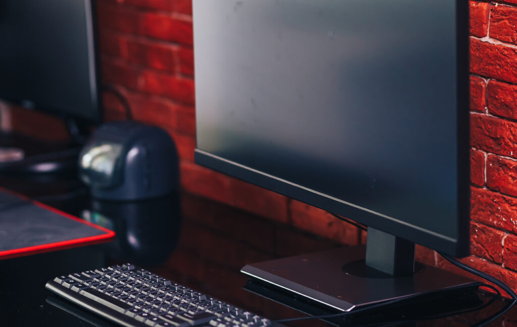 Два компьютерных монитора с черным экраном на столе