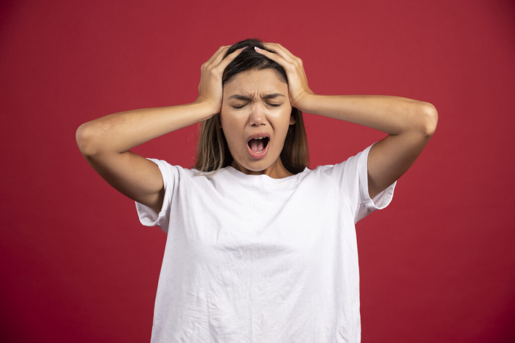 Молодая женщина держится за голову