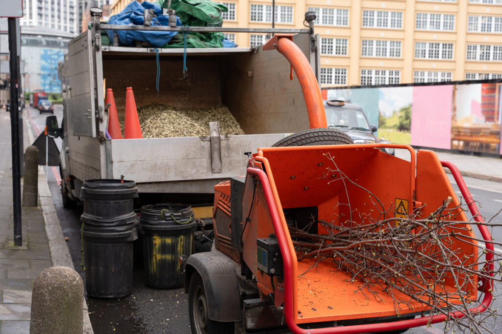 Ветки деревьев загружены в измельчитель
