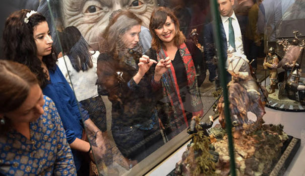 Люди разглядывают экспозицию из камня за стеклом